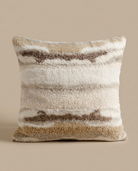 Textured pillow with striped pattern on a beige background