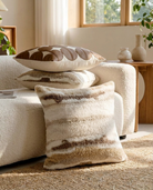 Decorative pillows on a textured surface with a neutral color palette