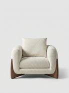 Beige armchair with wooden legs on a light gray background