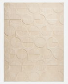 Beige area rug with geometric circle pattern on a plain background