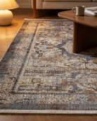 Patterned area rug in a living room setting with a coffee table and lamp.