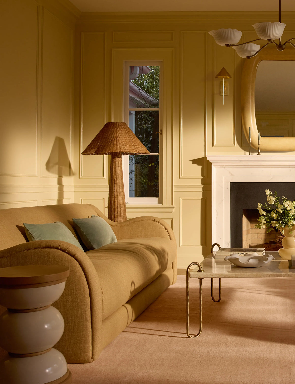Lova Faux Fur Pillow in Dune Mist, styled in a living room with lamp and fireplace
