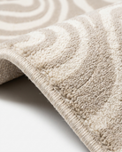 Close-up of a textured beige rug on a light background