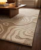 Beige patterned rug on a wooden floor with a wooden coffee table in the background.