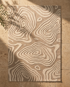 Beige and brown patterned rug on a stone floor
