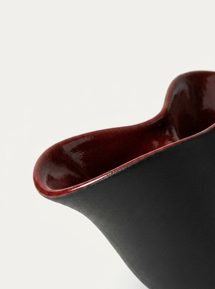 Skal Ceramic Vessel, close-up of oxblood-red interior glaze on matte black vessel