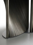 Close-up of a modern, curved wooden furniture piece with a detailed grain pattern.