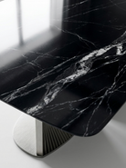 Marble-patterned black table with a metallic base on a light background