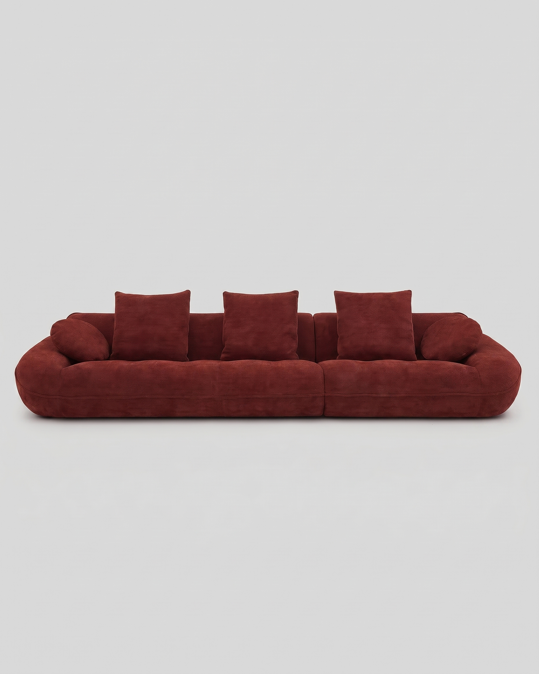 Red sofa with cushions on a light gray background