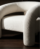 White textured chair against a dark wooden panel background